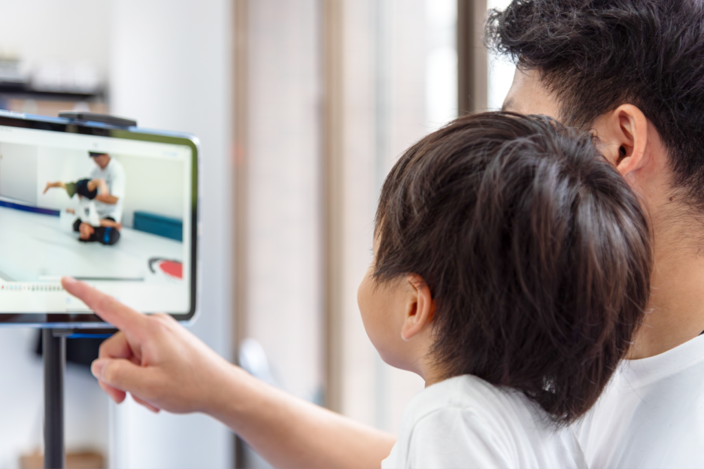 子どもが講師と一緒にタブレットでアクロバットの映像を確認している様子｜バク転パーソナル教室市川店