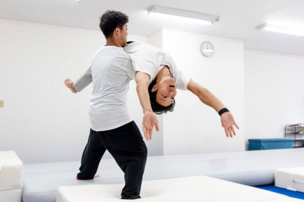 講師が大人の初めてのバク転を補助しているバク転パーソナル教室市川店のレッスン風景