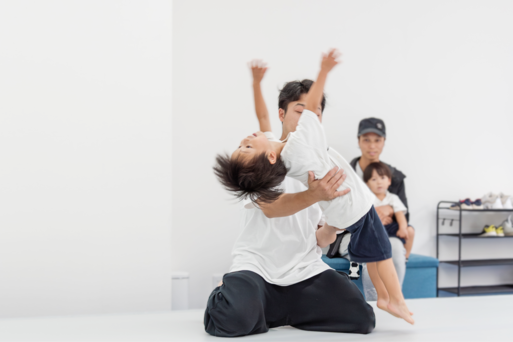 講師が子どものバク転を補助し、保護者が見守るバク転パーソナル教室市川店のレッスン風景